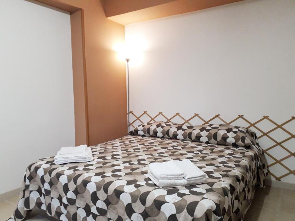 a bedroom with a black and white bed with towels on it at Liberty House in Marsala