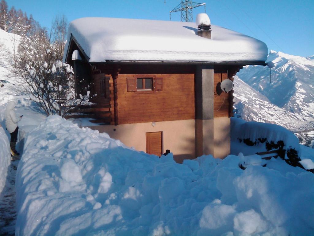 una pila de nieve delante de una casa en Chalet Lé Fèrtin, en La Tzoumaz