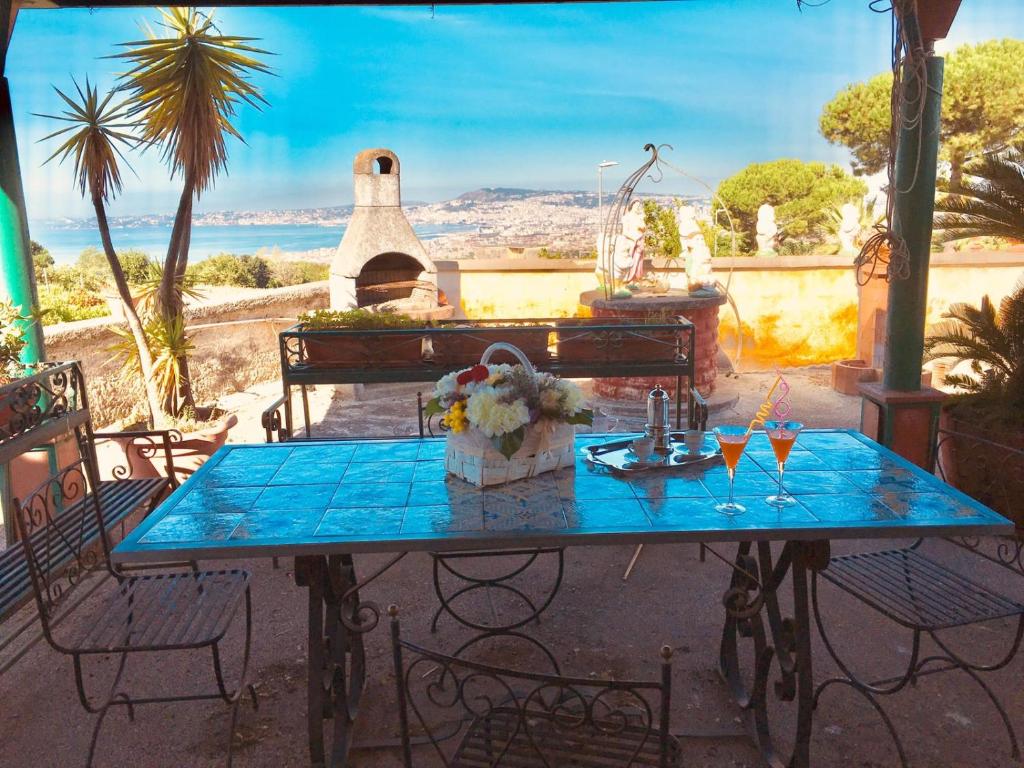 uma mesa azul com bebidas e um piano no pátio em B&B LA PIETRA em Ercolano