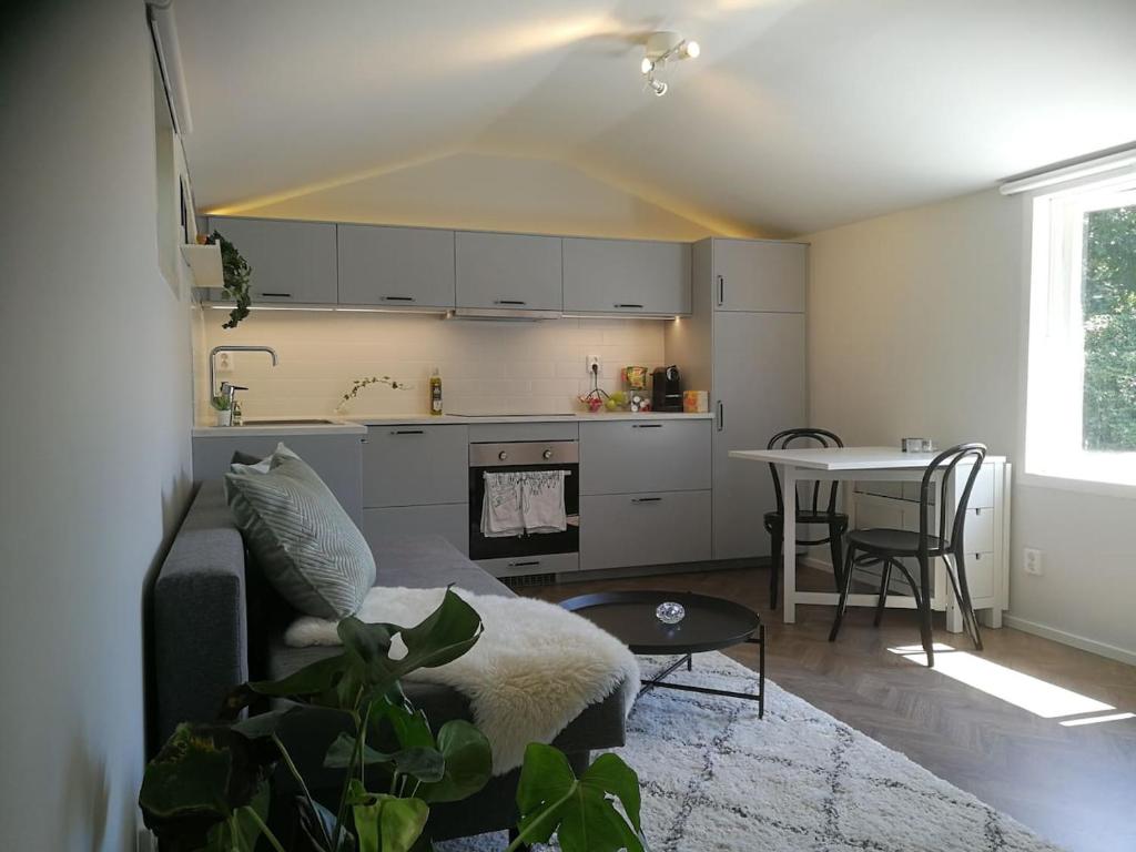eine Küche und ein Wohnzimmer mit einem Sofa und einem Tisch in der Unterkunft Hytten Skanör in Skanör med Falsterbo