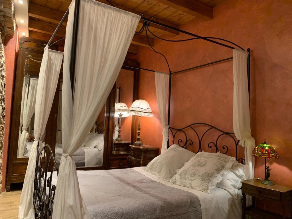 a bedroom with a canopy bed with white pillows at Il Giardino Segreto Arona, Charming Apartments in Arona