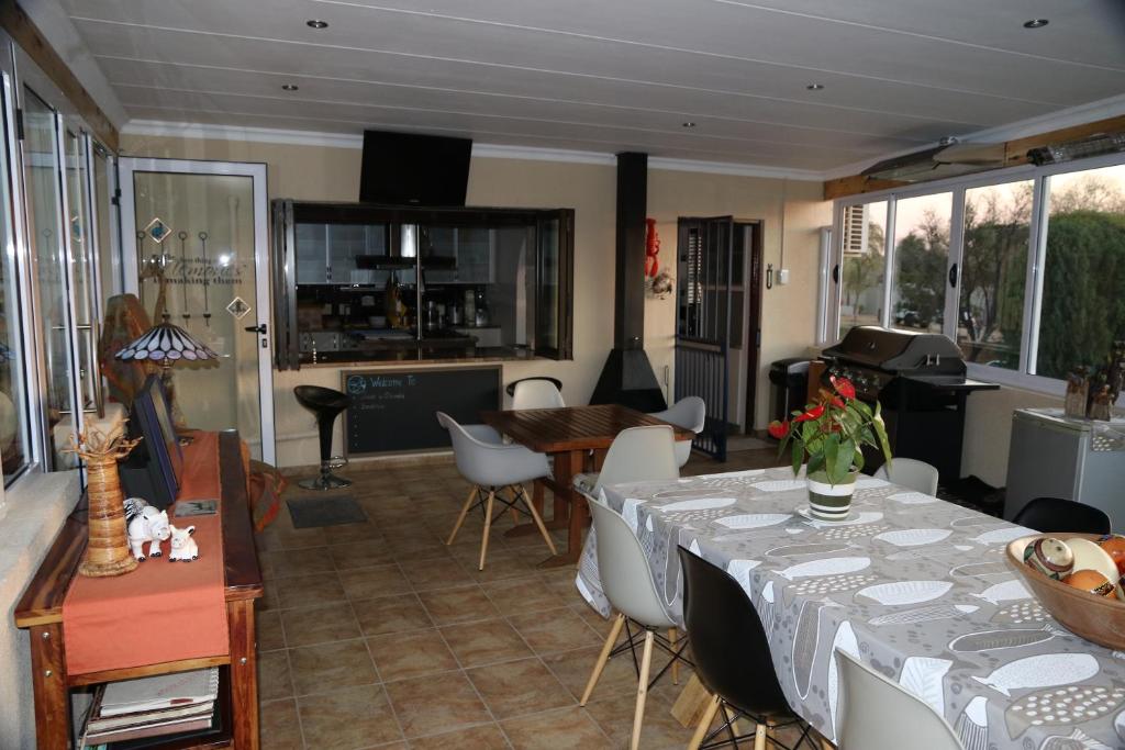 a living room with a table and a dining room at Ponciana Superior Guesthouse in Hartbeespoort