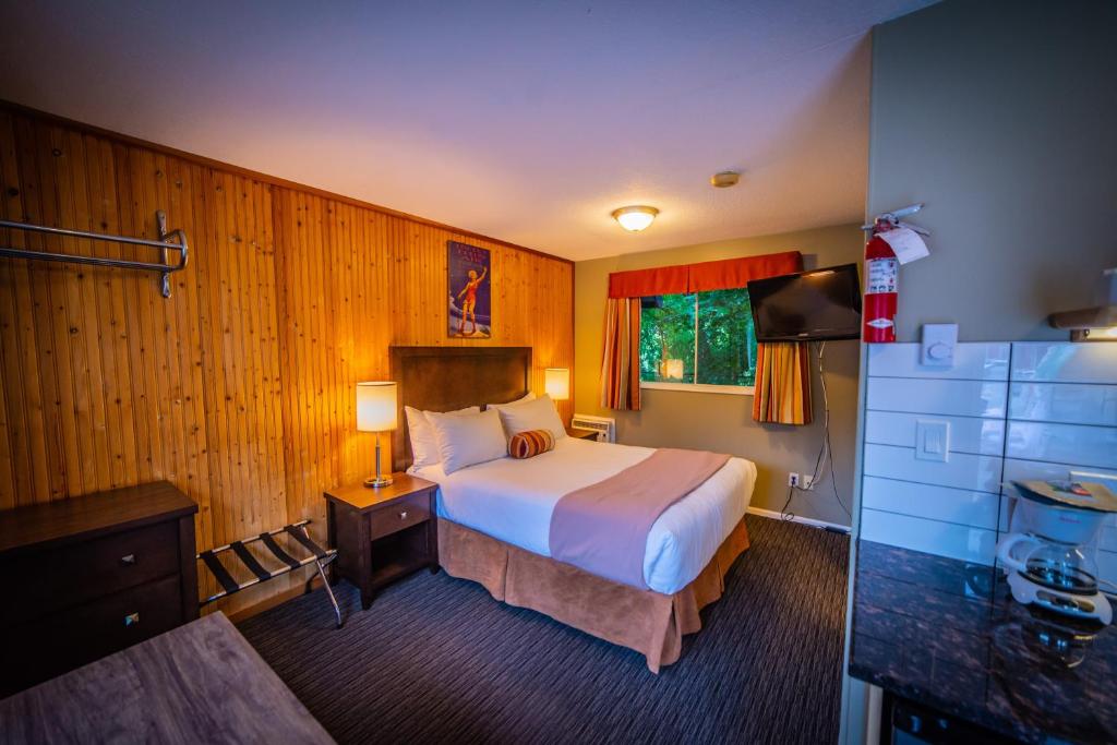 Habitación de hotel con cama y baño en Alpine Inn & Suites en Nelson