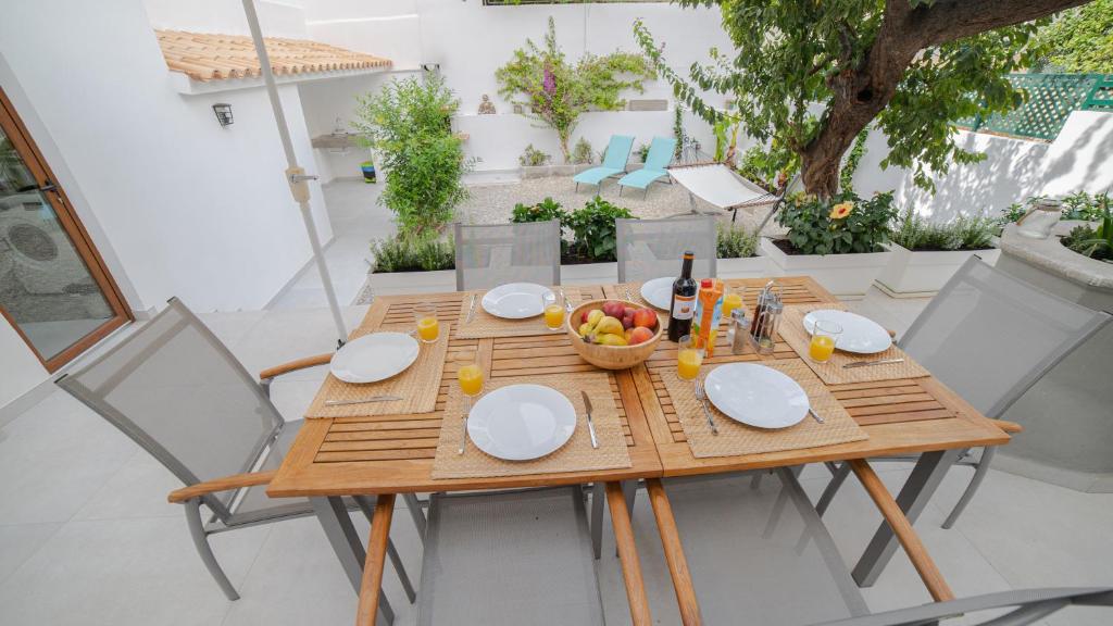 a wooden table with a bowl of fruit and a bottle of wine at City Center Palma in Palma de Mallorca