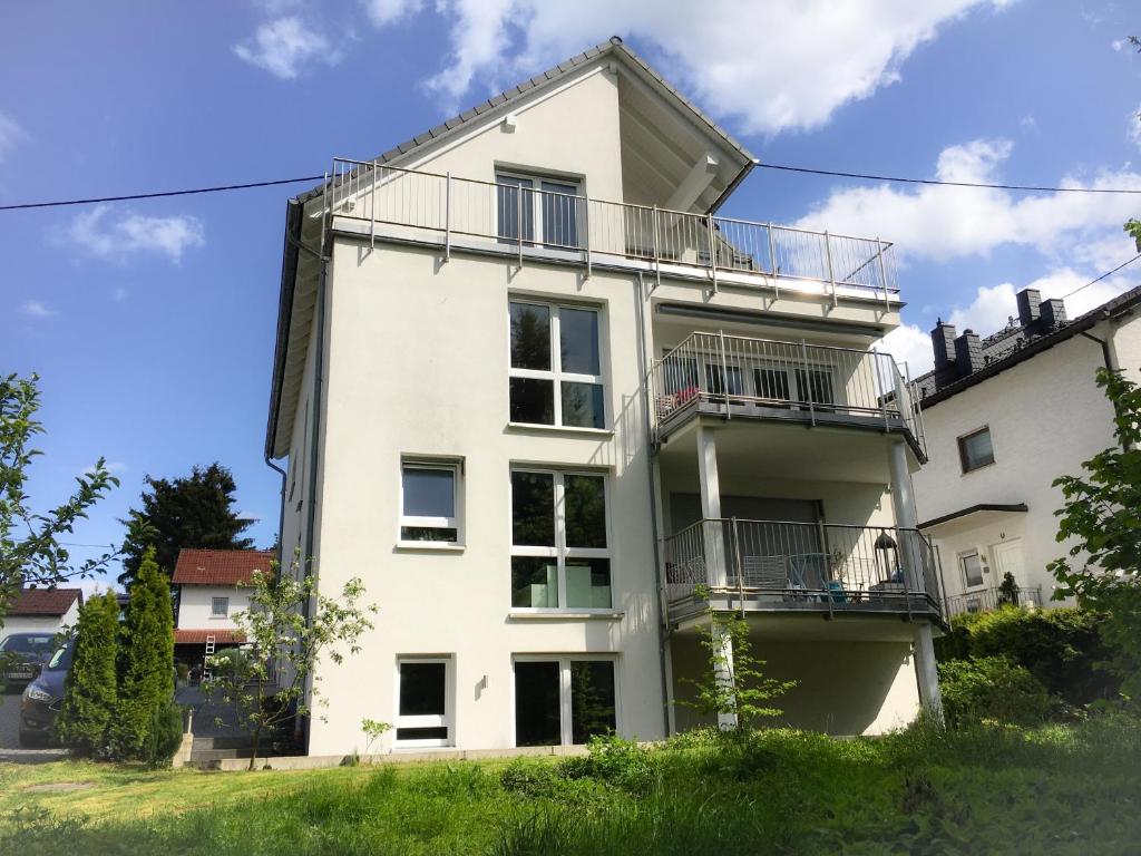 a white building with a balcony on it at Townus Apartments Wiesbaden in Wiesbaden