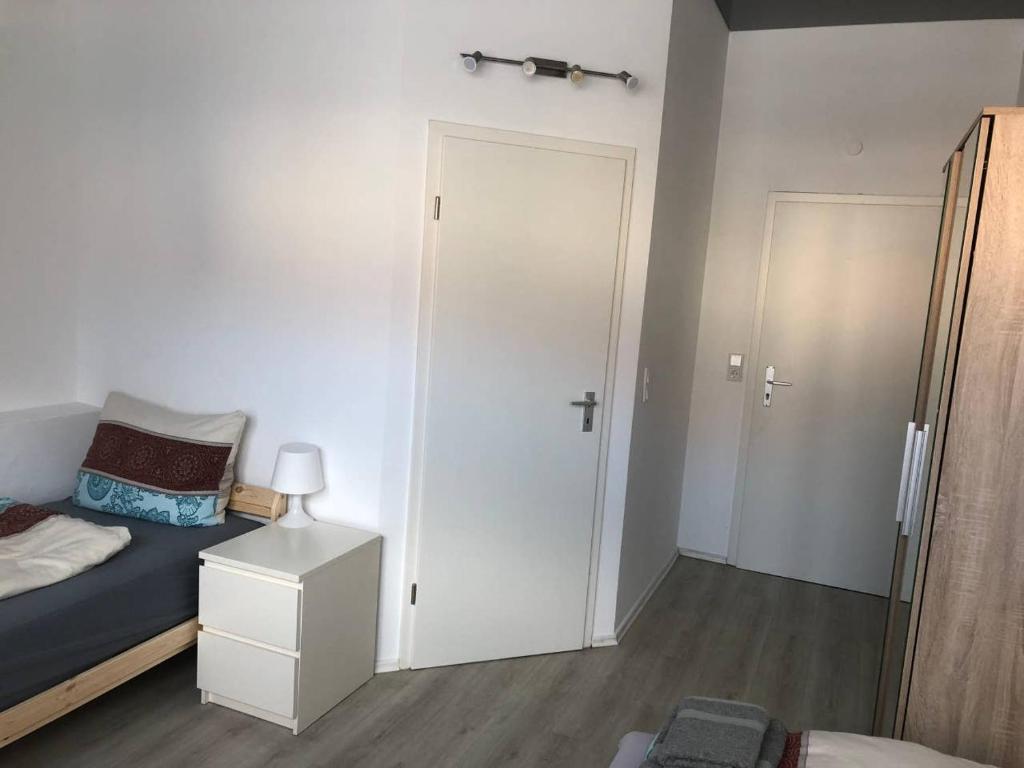 1 dormitorio con cama, armario y puerta en Zimmer 5, en Alzenau