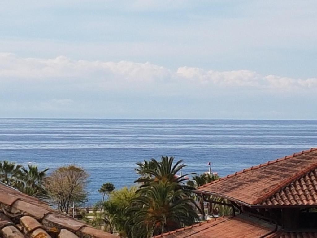 uma vista para o oceano a partir de uma casa em Le Palmaro em Menton