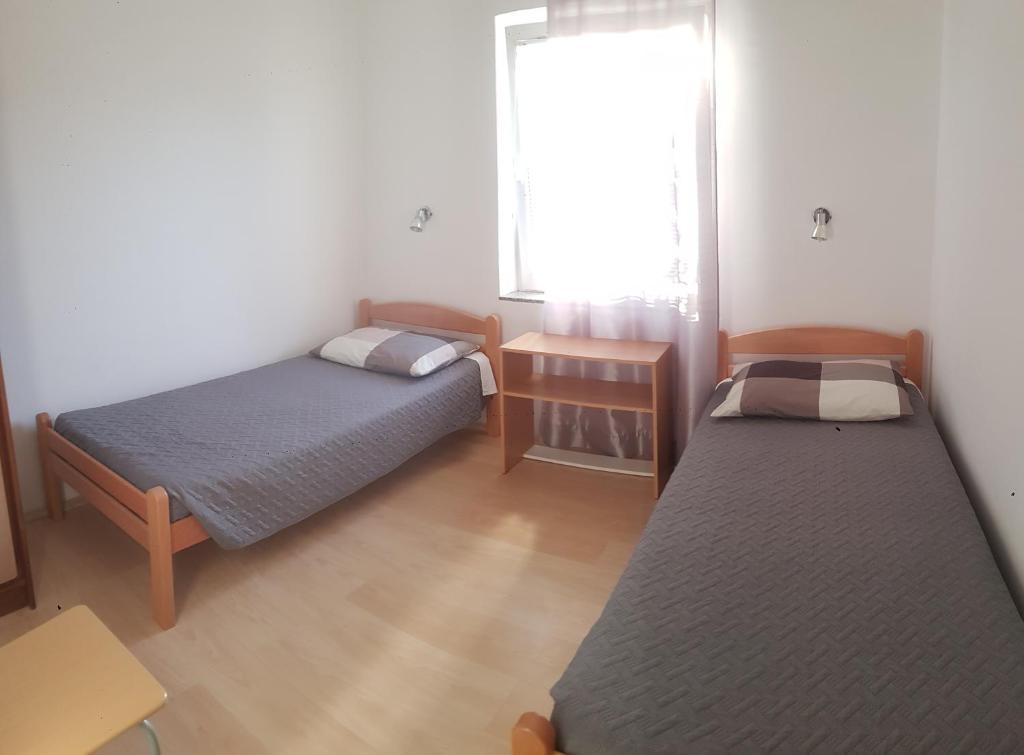 a small room with two beds and a window at Apartment Anita in Fažana