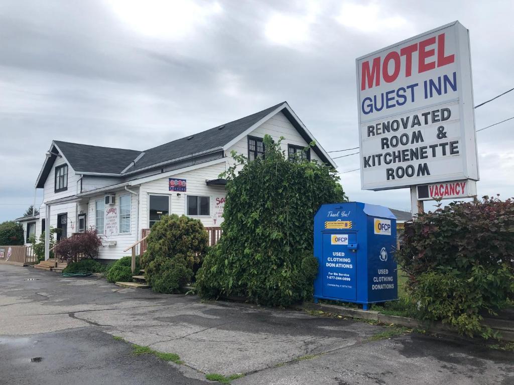 una casa con un cartel de posada de motel delante de ella en Guest Inn Motel, en Trenton