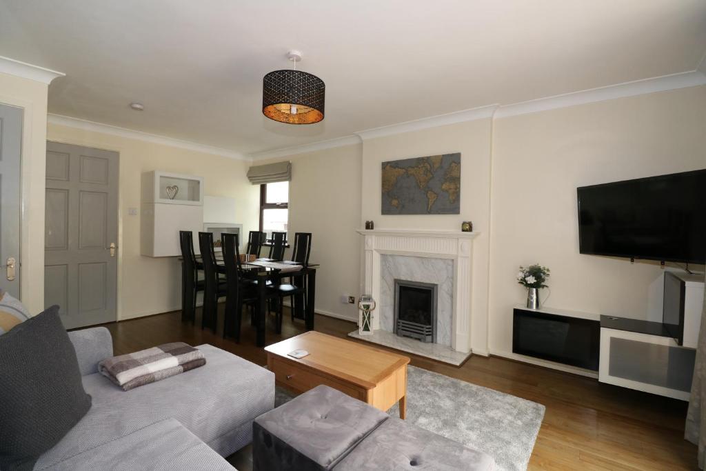 a living room with a couch and a fireplace at Peartree Cottage - Derby in Derby