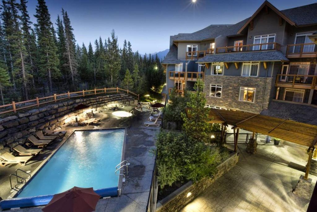 an outdoor swimming pool in front of a house at Luxurious & Spacious Mountain Retreat in Canmore