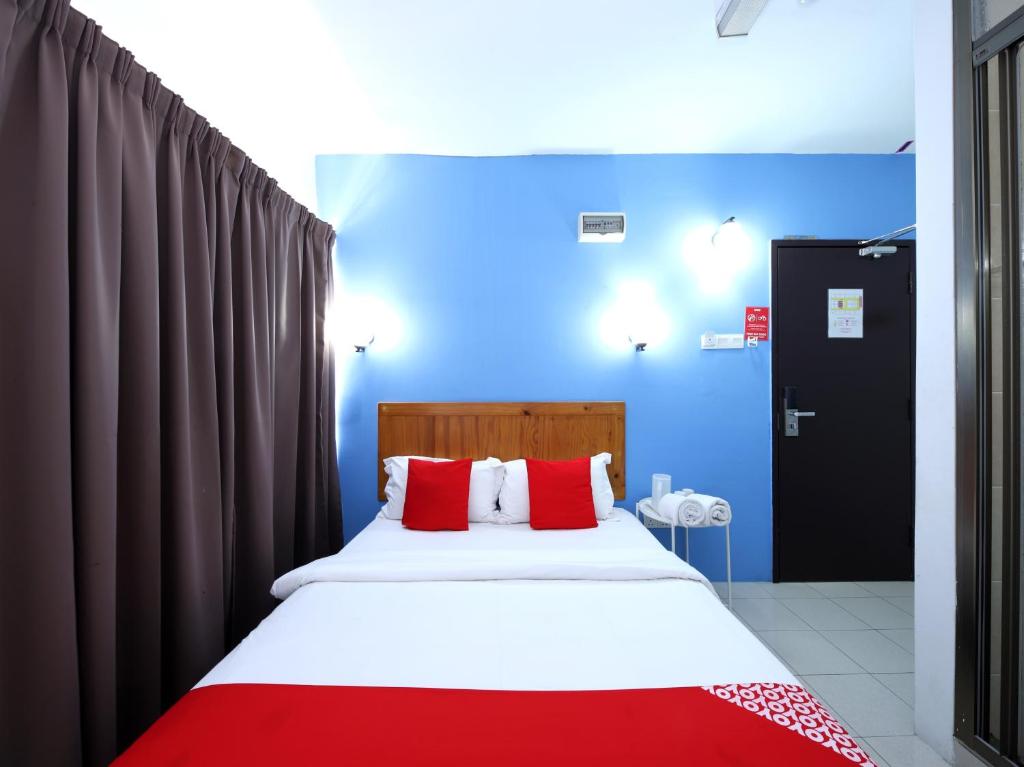 una camera da letto con un grande letto con cuscini rossi di Super OYO 502 Midah Inn Puchong a Puchong