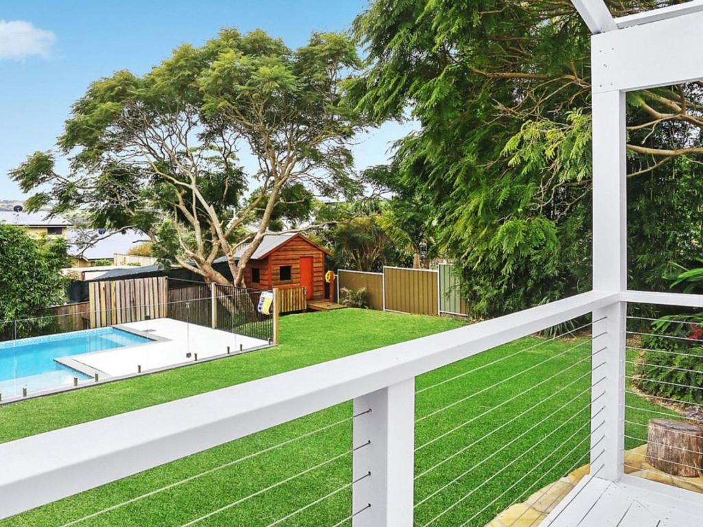 a view of a yard with a pool and a fence at Amalfi Beach House in Gerringong