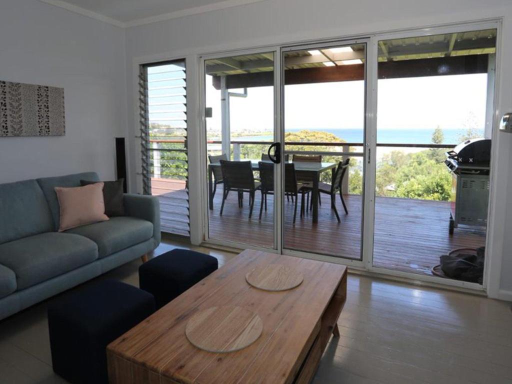 a living room with a couch and a table at Brilliant Ocean Views in Gerroa
