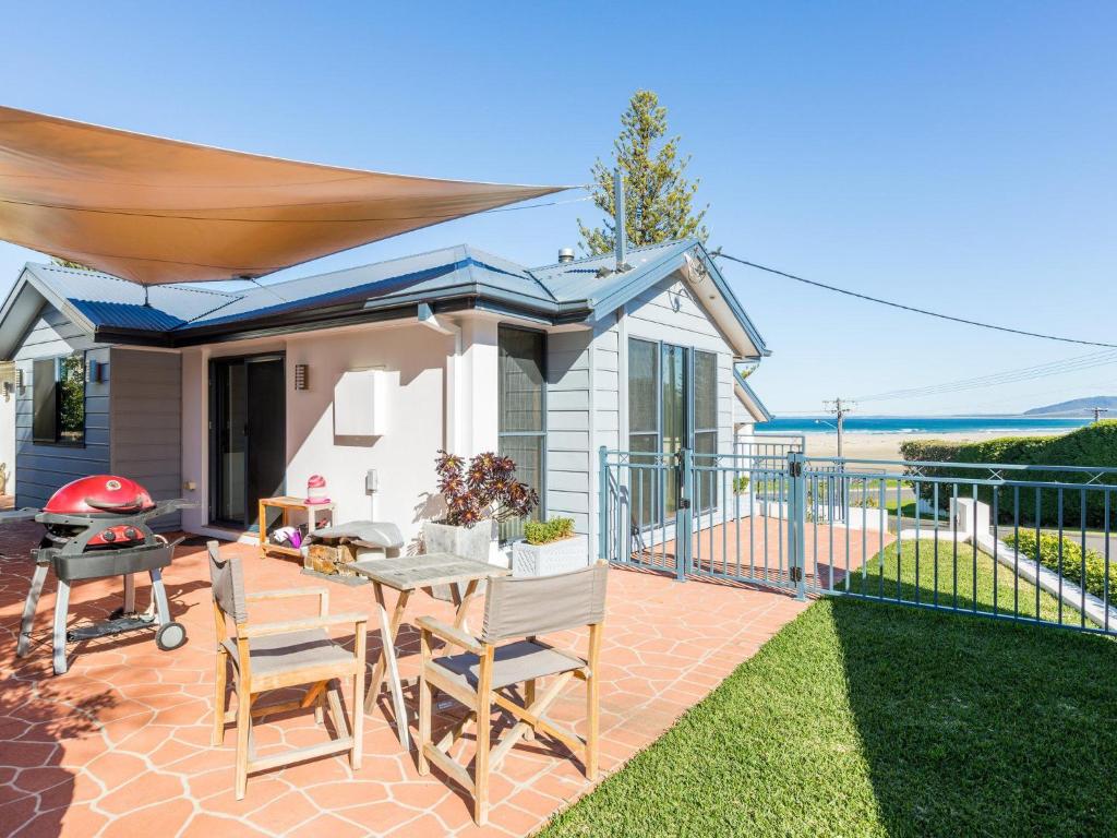a patio with a table and chairs and a grill at Coastal Haven at Gerroa in Gerroa