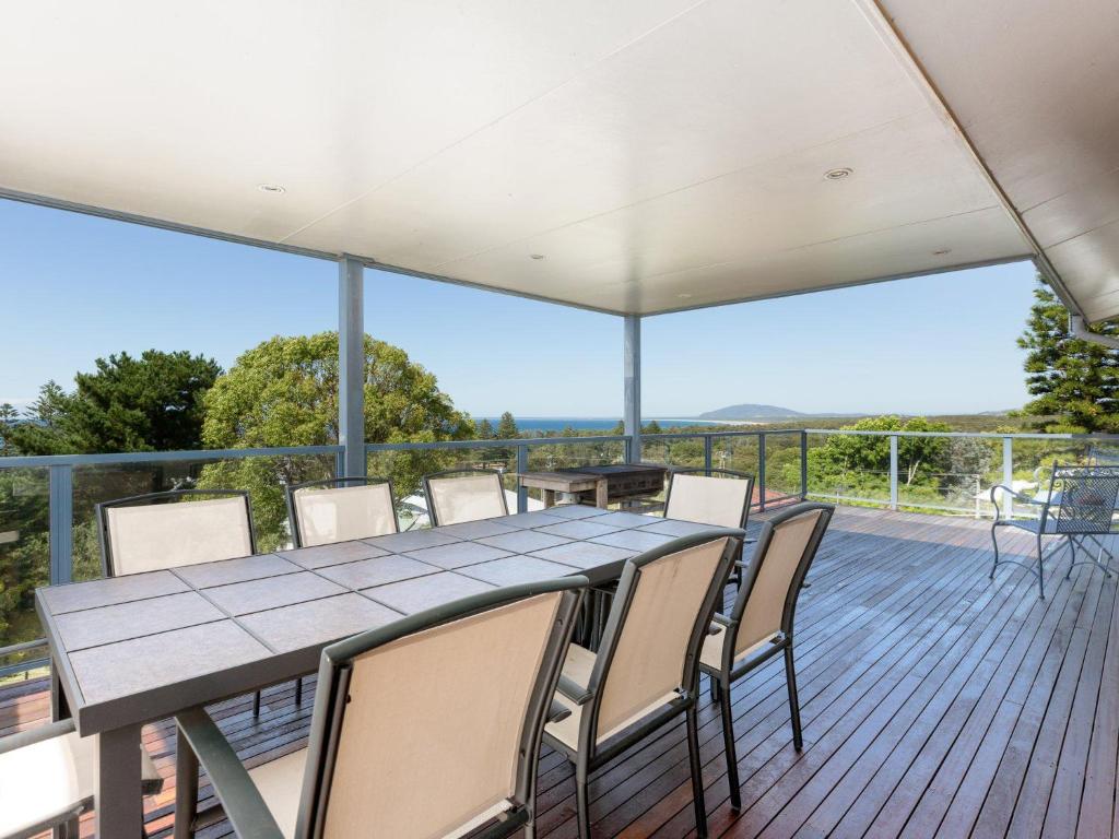 a table and chairs on a deck with a view at Summerhill View in Gerroa