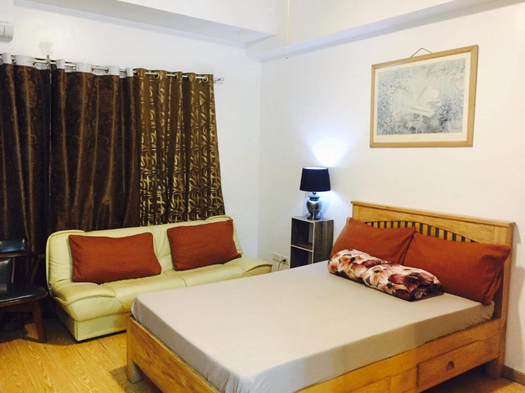 a bedroom with a bed and a couch at Cedar peak unit 608 in Baguio