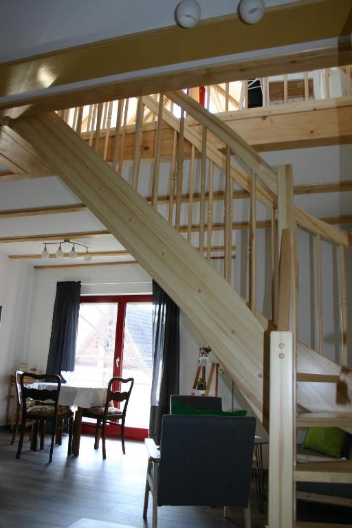 a wooden staircase in a room with a table and chairs at Apartment Jakobsweg GbR in Pettstädt