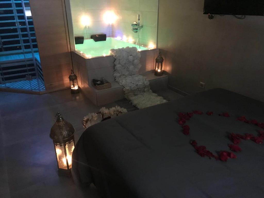 Zimmer mit einer Badewanne und einem Tisch mit Rosen in der Unterkunft LE NID A BULLES in Bischheim