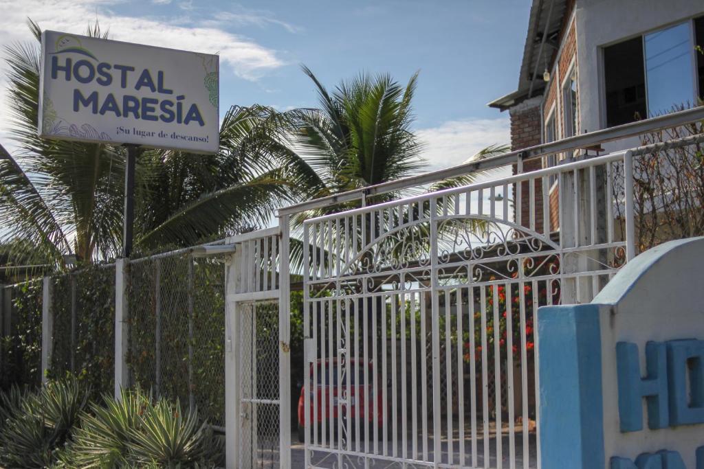 Una cerca blanca con un letrero de hospital Masasha al lado en Hostal Maresia, en Data de Posorja