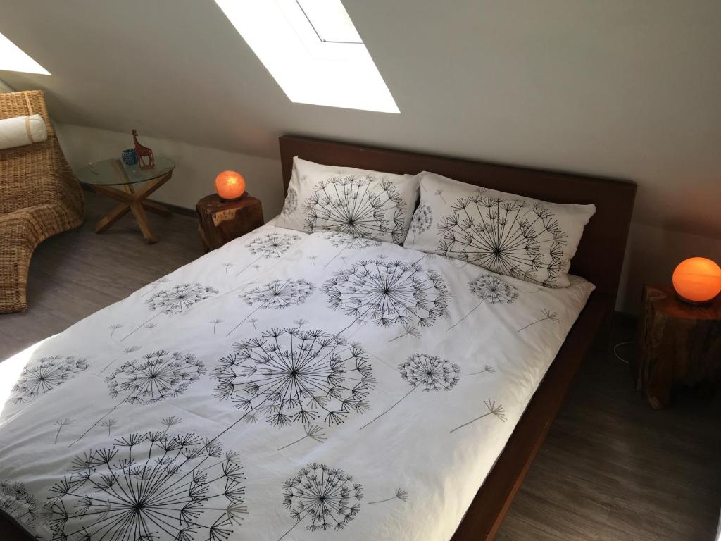 a bed with a white comforter with flowers on it at FEWO Allerblick in Celle