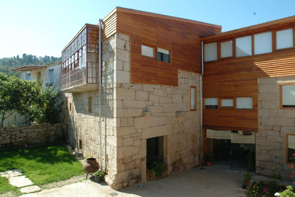 una casa construida con una pared de piedra en Casa Rural Vilaboa en Allariz