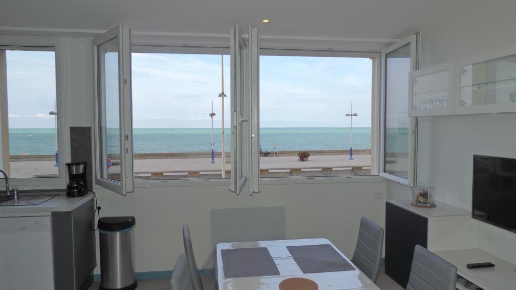 a room with a window with a view of the ocean at FRONT DE MER ET FALAISE 317 1er Étage Lit fait WifI Taxe de Séjour incluse in Le Tréport
