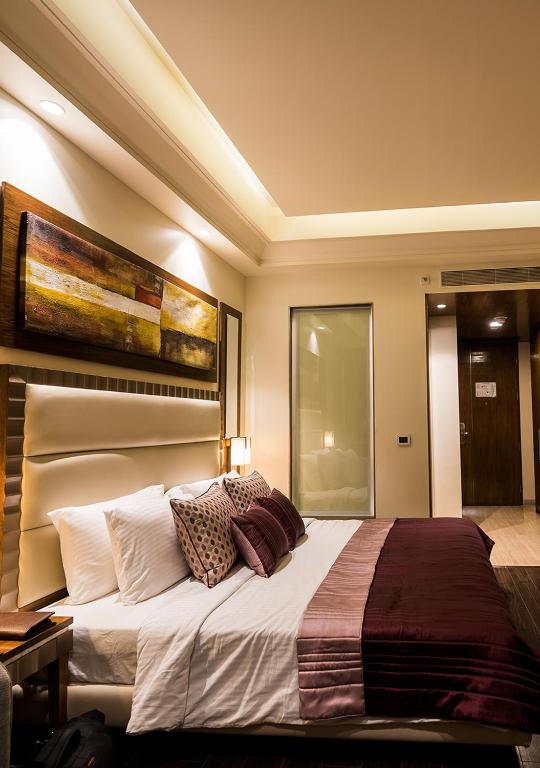 Postel nebo postele na pokoji v ubytování Ramada Gurgaon Central