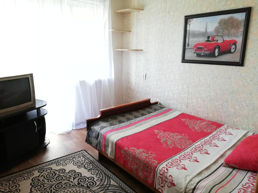 a bedroom with a bed and a red car on the wall at Заслонова 24 центр города in Salihorsk