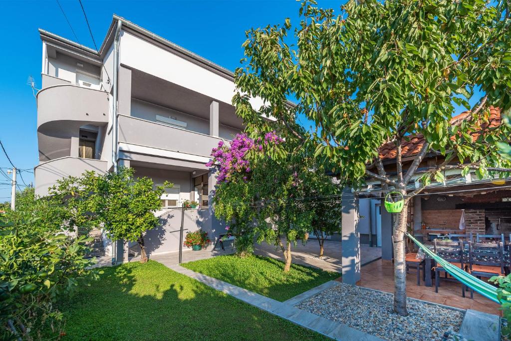 an image of a house with trees in front of it at Apartments Luky in Zadar