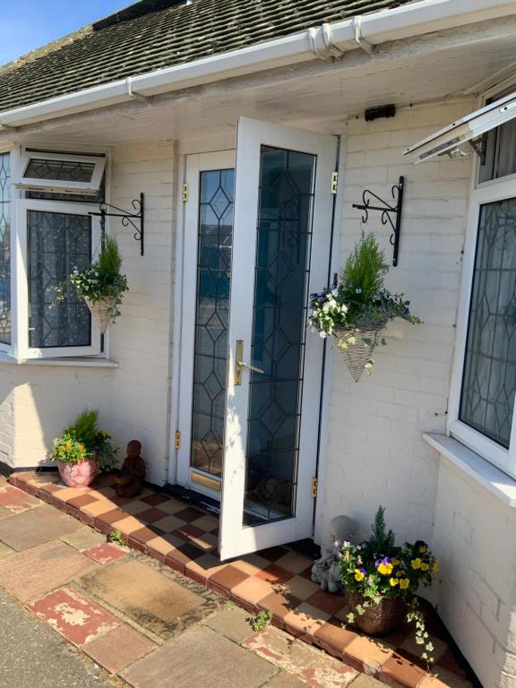 uma porta da frente de uma casa com vasos de plantas em Stanwell Stansted Airport em Takeley