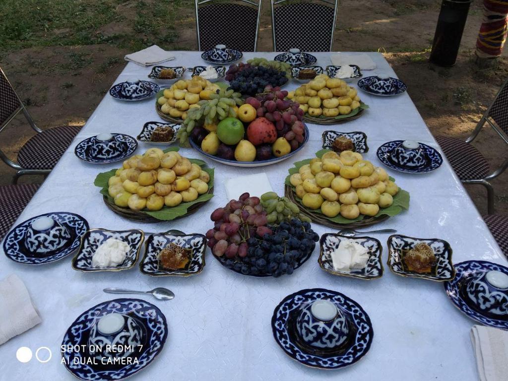 ein Tisch mit Tafeln verschiedener Obstarten darauf in der Unterkunft Uvaysiy family guest house in Margilan