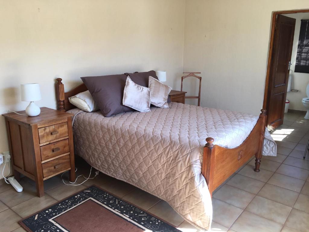 1 dormitorio con 1 cama grande con mesita de noche y 1 cama sidx sidx sidx sidx en Forget-Me-Not Cottage en Krugersdorp