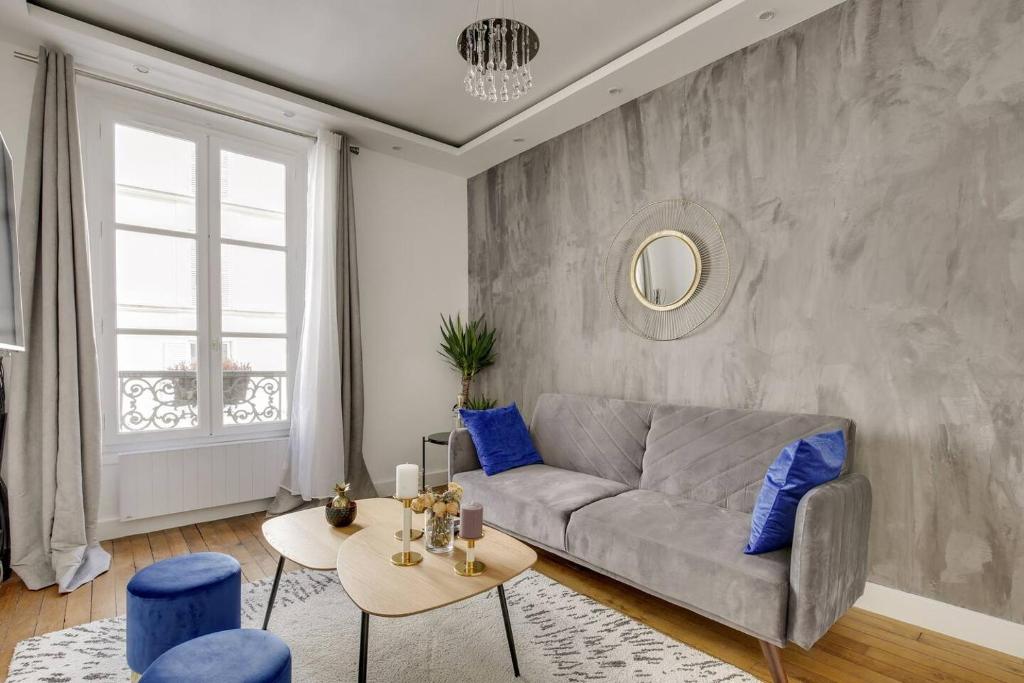 a living room with a couch and a table at Design Apt 4 pers - Paris 8ème in Paris