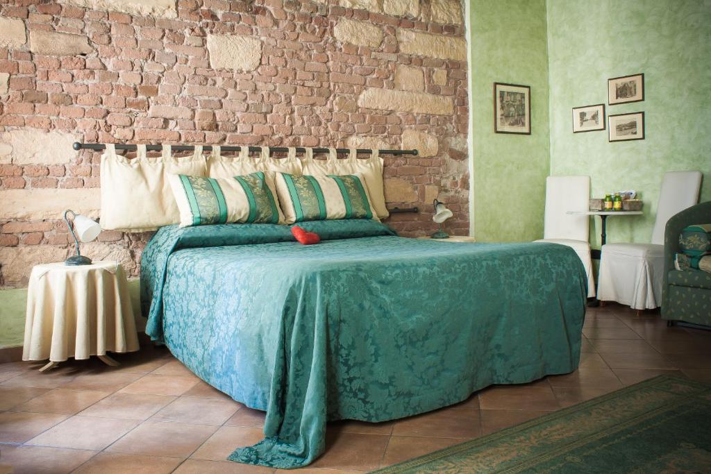 ヴェローナにあるAnfiteatro B&Bのレンガの壁、ベッド付きのベッドルーム1室