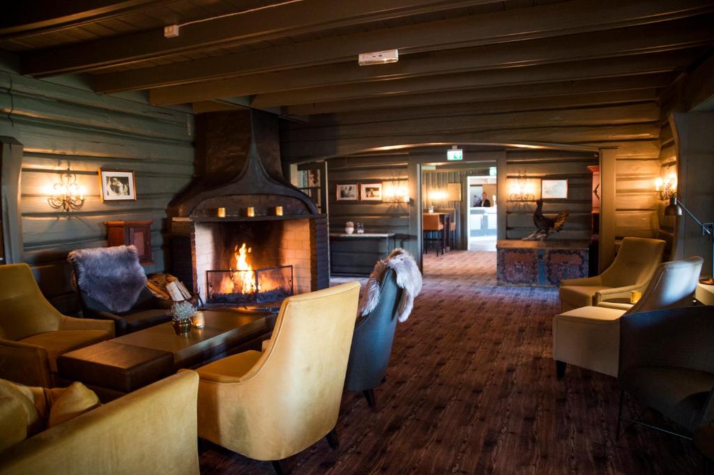 una sala de estar con chimenea en una casa en Geilo Hotel en Geilo