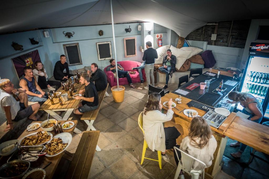a group of people sitting at tables in a room at Atlantic Point Backpackers in Cape Town