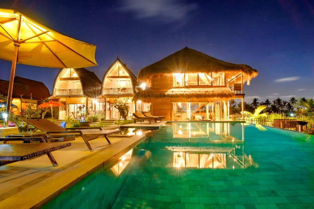 a resort with a swimming pool at night at Canggu Wooden Green Paradise in Canggu