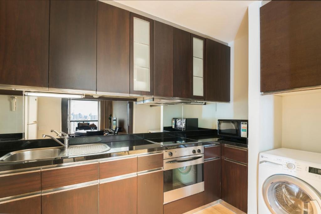 A compact fitted kitchen with full-size cooking and laundry appliances.