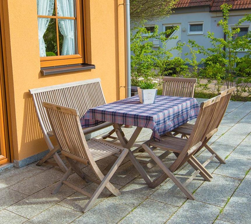 een houten tafel met 2 stoelen en een tafelkleed bij Steigerwaldpension in Wiesentheid