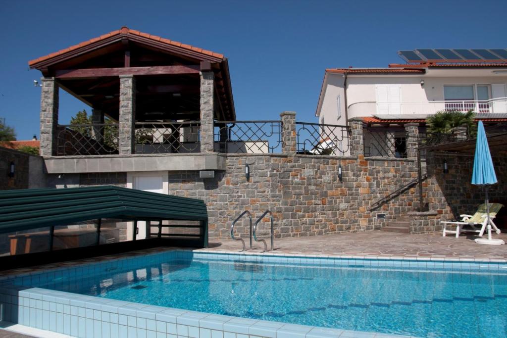 a swimming pool in front of a house at Exclusive Apartments DEBELI RTIČ in Ankaran