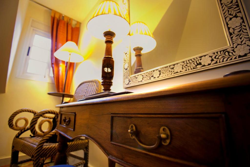 a dresser with two lamps and a mirror at Hotel Hacienda Montenmedio in Vejer de la Frontera