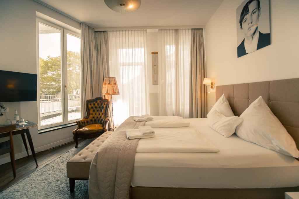 a hotel room with a large bed and a window at MAISON MARSIL - Boutique Hotel Köln in Cologne