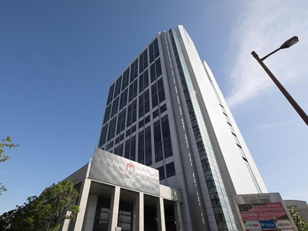 un grand bâtiment avec un éclairage de rue devant lui dans l'établissement Izumisano Center Hotel Kansai International Airport, à Izumi-Sano