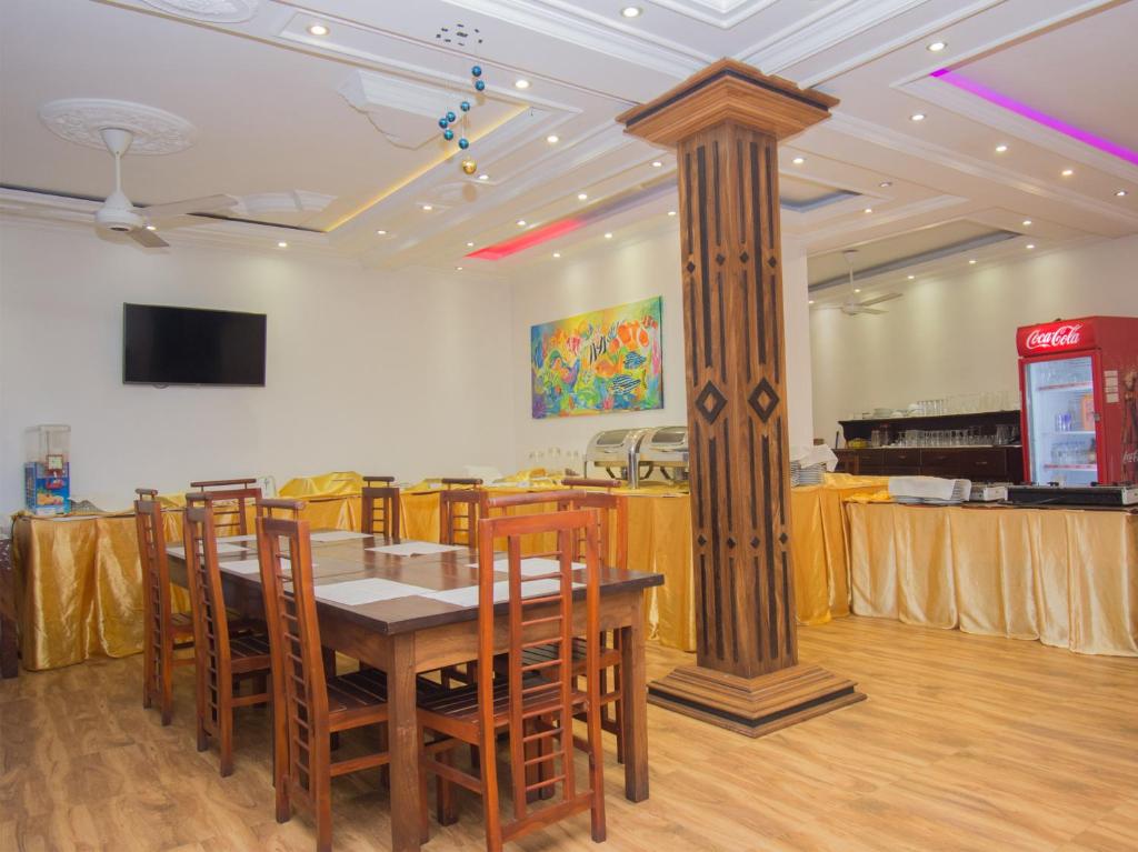 a dining room with a table and a pillar at Gloria Grand Hotel in Unawatuna