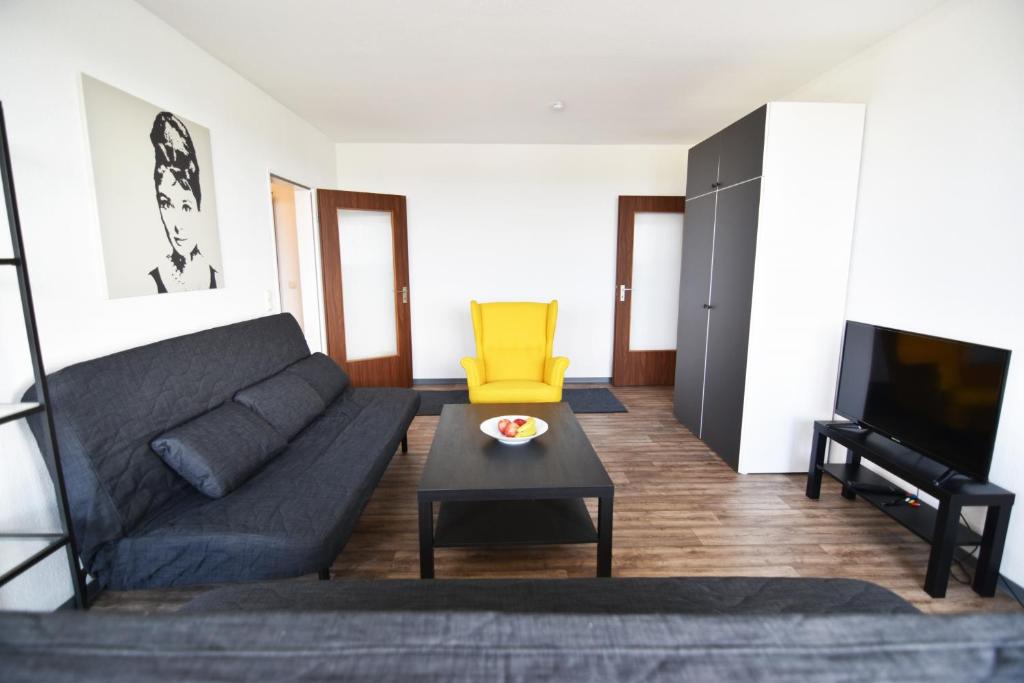 a living room with a couch and a yellow chair at Ferienwohnung in Duisburg Monteurwohnung in Duisburg