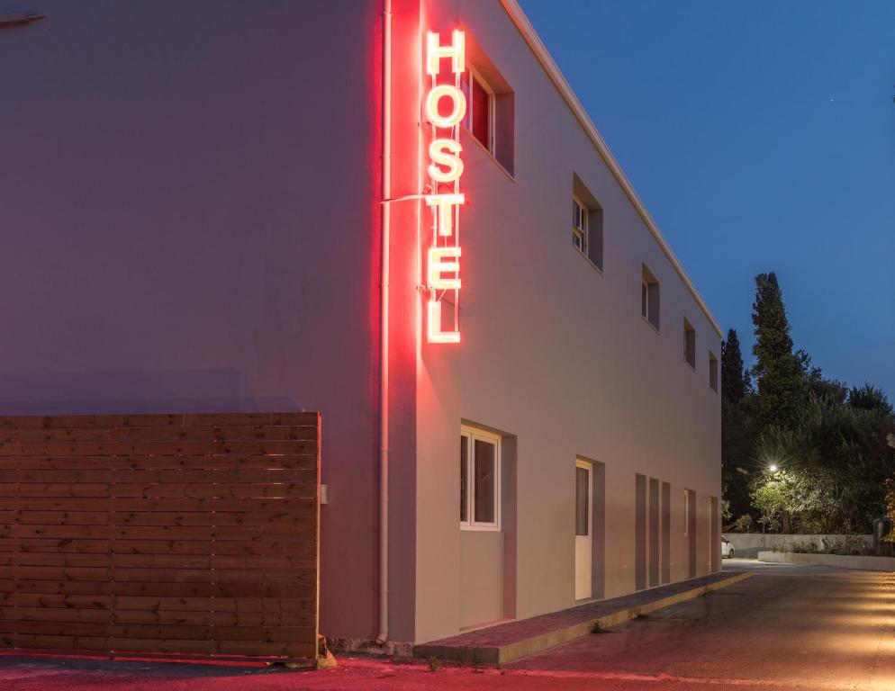 a neon sign on the side of a building at Local Hostel & Suites in Corfu
