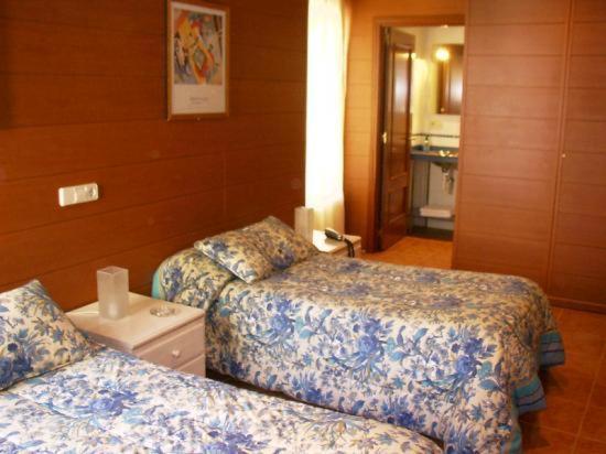 a hotel room with two beds and a bathroom at Pension Casa 400 in Vitoria-Gasteiz