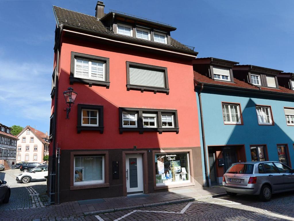un edificio rojo con ventanas blancas en una calle en Ferienwohnung Claudi, en Zell am Harmersbach