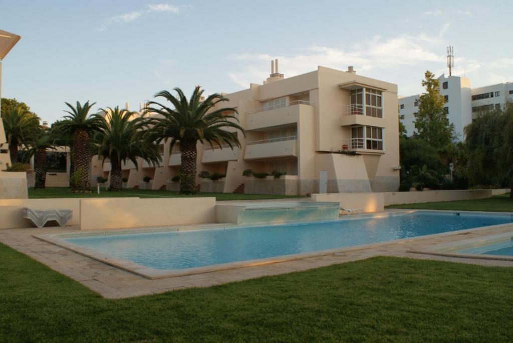 una grande piscina di fronte a un edificio di Akisol Vilamoura Hill a Vilamoura